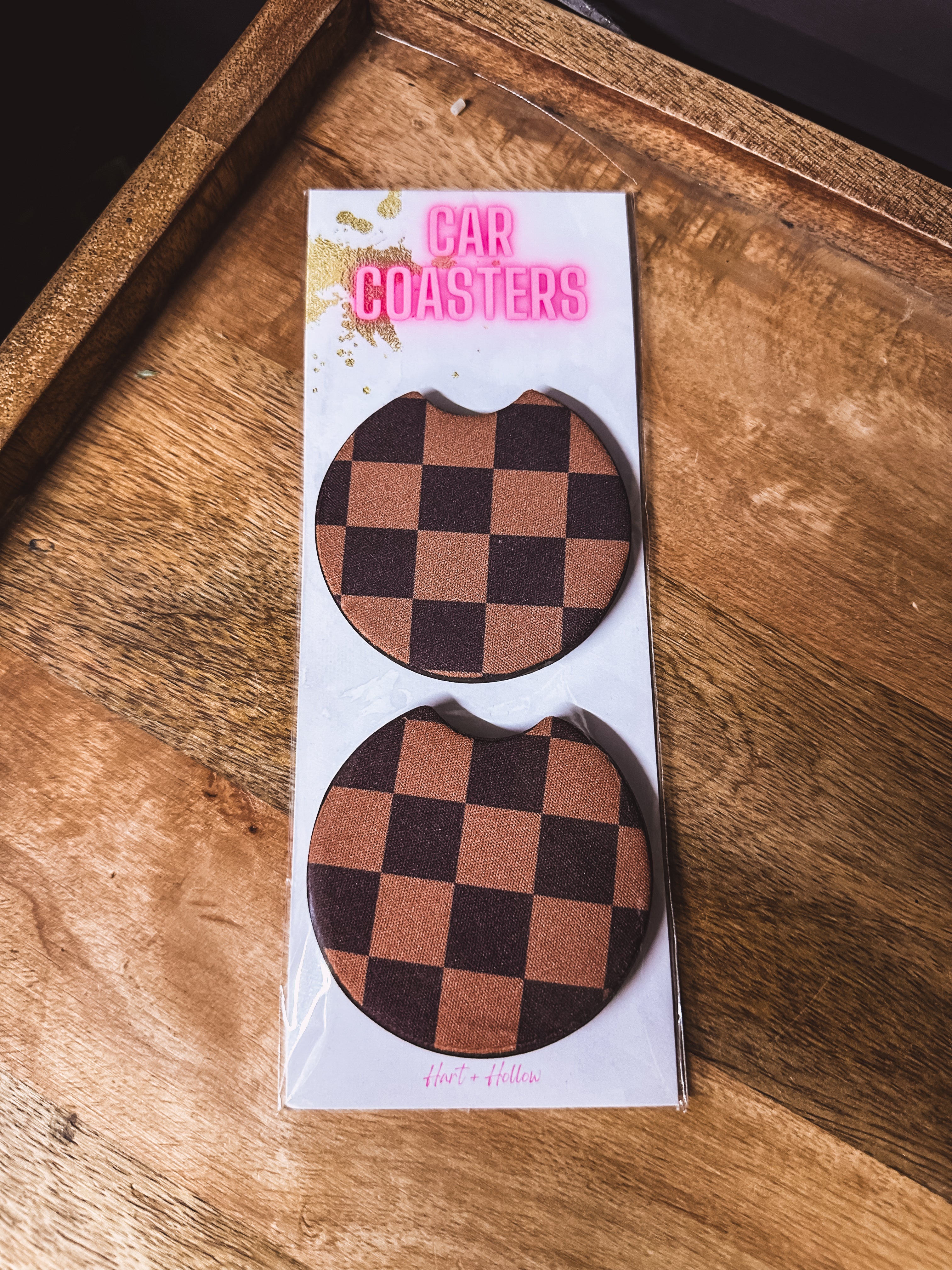 Two black and brown checkered neoprene car coasters.