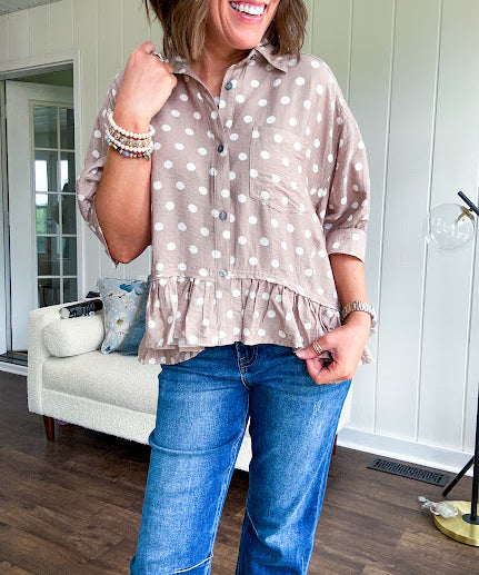 Light, flowy sand colored button down top with collar, 3/4 cuffed sleeves and front pocket with seam detail and ruffled hemline.