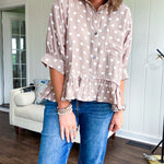 Light, flowy sand colored button down top with collar, 3/4 cuffed sleeves and front pocket with seam detail and ruffled hemline.