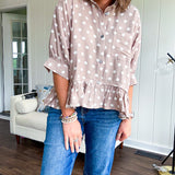 Light, flowy sand colored button down top with collar, 3/4 cuffed sleeves and front pocket with seam detail and ruffled hemline.