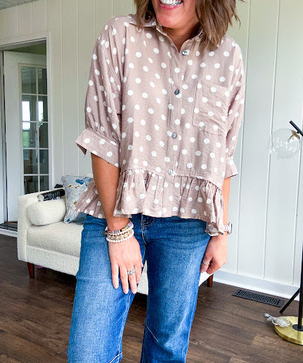 Light, flowy sand colored button down top with collar, 3/4 cuffed sleeves and front pocket with seam detail and ruffled hemline.