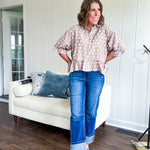 Light, flowy sand colored button down top with collar, 3/4 cuffed sleeves and front pocket with seam detail and ruffled hemline.