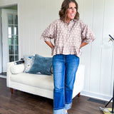 Light, flowy sand colored button down top with collar, 3/4 cuffed sleeves and front pocket with seam detail and ruffled hemline.
