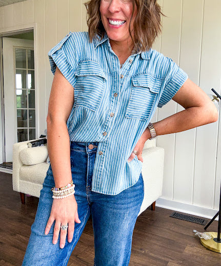 Light chambray button down top with white stripe detail, tab sleeves and front pockets.