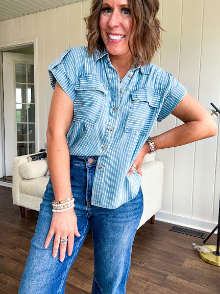 Light chambray button down top with white stripe detail, tab sleeves and front pockets.