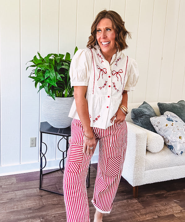 Thin, lightweight cotton barrel style pants with cream and red stripes and matching patchwork throughout, button fly and silver grommet belt loops with red rope belt.