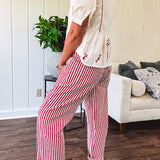 Thin, cotton linen blend cream top with short, puff sleeves, mock neck collar, red buttons down the front, a ruffle at the waist and red bow and floral embroidery throughout.