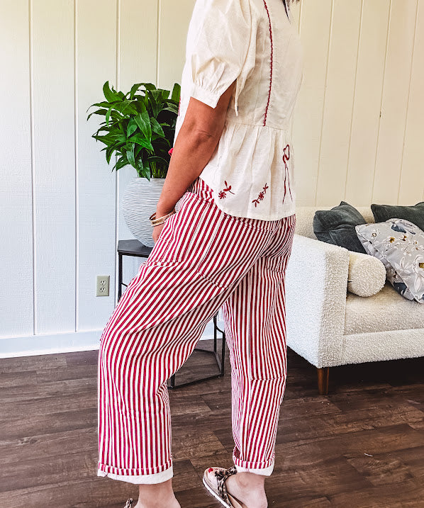 Thin, lightweight cotton barrel style pants with cream and red stripes and matching patchwork throughout, button fly and silver grommet belt loops with red rope belt.