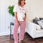 Thin, lightweight cotton barrel style pants with cream and red stripes and matching patchwork throughout, button fly and silver grommet belt loops with red rope belt.