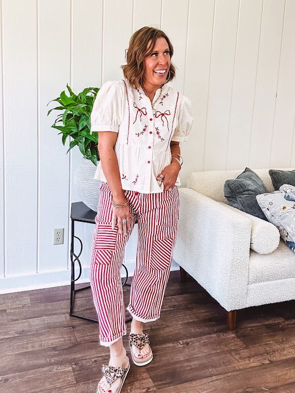Thin, lightweight cotton barrel style pants with cream and red stripes and matching patchwork throughout, button fly and silver grommet belt loops with red rope belt.