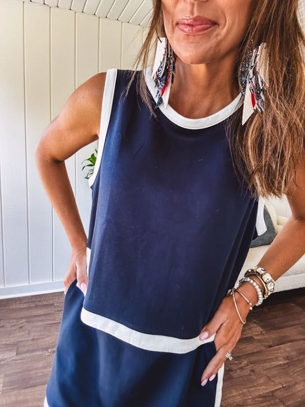 Buttery soft navy wide strap tank in cool navy with white trim at the round neck, sleeves and split hem with a button up back in matching white trim.