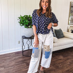 Creamy wide-leg pants, denim-like cotton material with silver grommet belt loops and a coordinating rope belt, button fly and oversized pockets, and striped patchwork in sand, denim, navy, and white creates visual interest down the legs.
