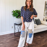 Creamy wide-leg pants, denim-like cotton material with silver grommet belt loops and a coordinating rope belt, button fly and oversized pockets, and striped patchwork in sand, denim, navy, and white creates visual interest down the legs.