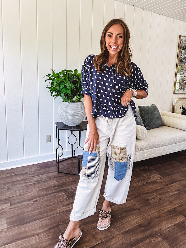 Creamy wide-leg pants, denim-like cotton material with silver grommet belt loops and a coordinating rope belt, button fly and oversized pockets, and striped patchwork in sand, denim, navy, and white creates visual interest down the legs.