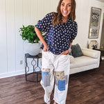 Creamy wide-leg pants, denim-like cotton material with silver grommet belt loops and a coordinating rope belt, button fly and oversized pockets, and striped patchwork in sand, denim, navy, and white creates visual interest down the legs.