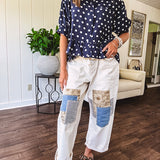 Creamy wide-leg pants, denim-like cotton material with silver grommet belt loops and a coordinating rope belt, button fly and oversized pockets, and striped patchwork in sand, denim, navy, and white creates visual interest down the legs.