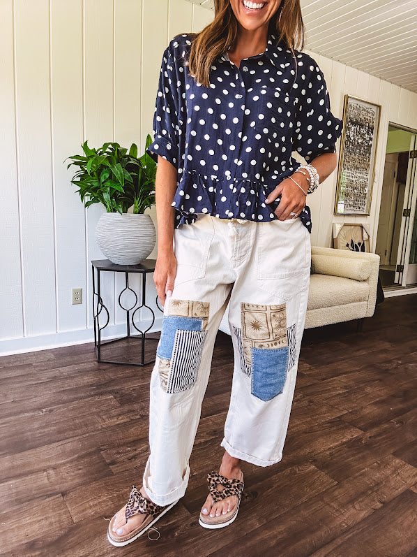 Creamy wide-leg pants, denim-like cotton material with silver grommet belt loops and a coordinating rope belt, button fly and oversized pockets, and striped patchwork in sand, denim, navy, and white creates visual interest down the legs.