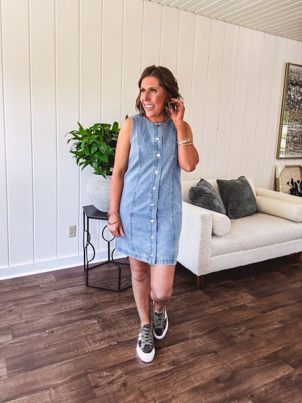 Medium wash true denim sleeveless mini dress with silver snap button front and front seams.