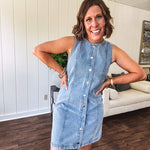Medium wash true denim sleeveless mini dress with silver snap button front and front seams.