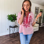 Lightweight cotton white and berry striped 3/4 sleeve top with berry trim at the mock neck and V neck and embroidery at the yoke with elastic cuffs and loose hem.