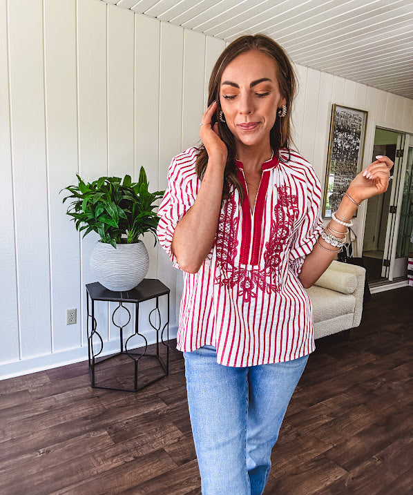 Lightweight cotton white and berry striped 3/4 sleeve top with berry trim at the mock neck and V neck and embroidery at the yoke with elastic cuffs and loose hem.