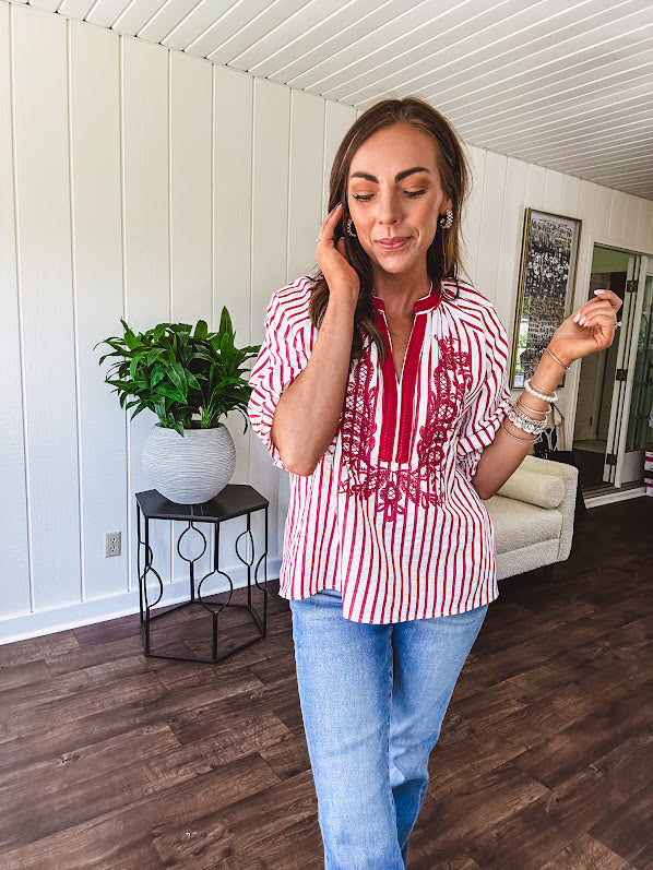 Lightweight cotton white and berry striped 3/4 sleeve top with berry trim at the mock neck and V neck and embroidery at the yoke with elastic cuffs and loose hem.