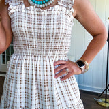 This mocha plaid midi dress is your new summer obsession. The smocked bodice hugs in all the right places while the tiered, flowy skirt does the twirling for you. Ruffled straps and trim add that playful touch that makes heads turn, and the slip lining keeps things cool and comfortable from brunch to sunset.