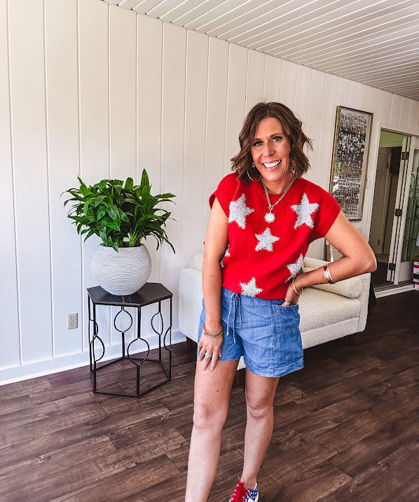 Bold red sweater vest with silver fuzzy stars throughout.