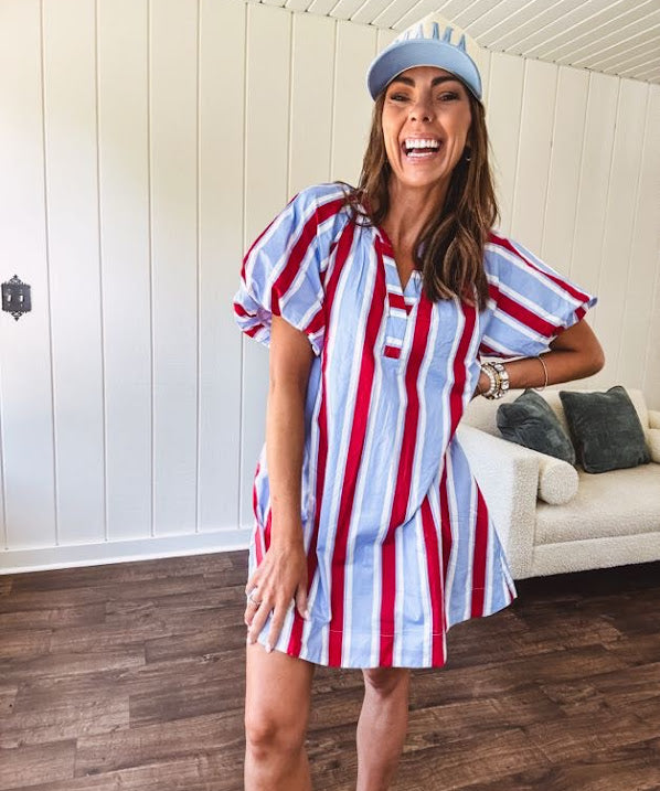 Light blue, white and red striped mini dress featuring a V neck and mock collar, puffed sleeves and pockets.