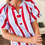 Light blue, white and red striped mini dress featuring a V neck and mock collar, puffed sleeves and pockets.