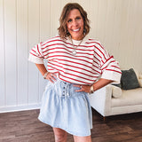 Light wash Tencel mini skirt with partial metal button down front with pleats and elastic drawstring waist.