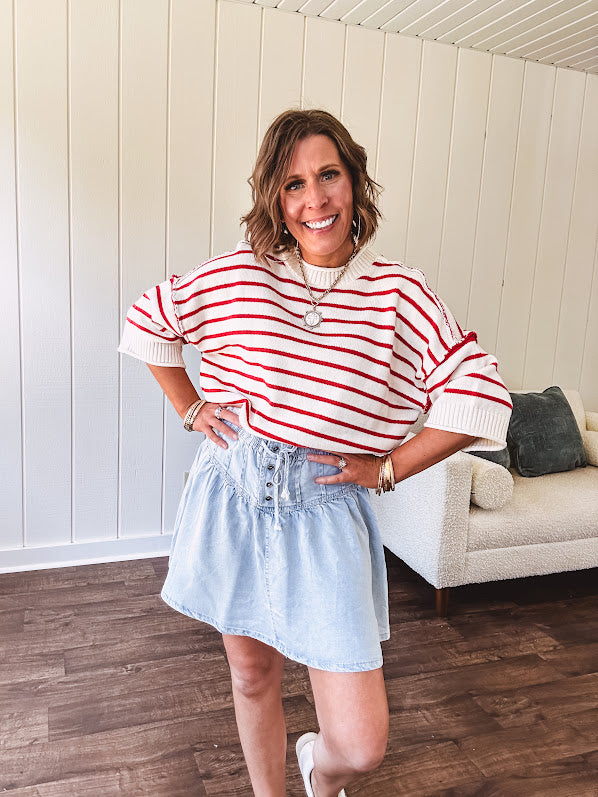 Light wash Tencel mini skirt with partial metal button down front with pleats and elastic drawstring waist.