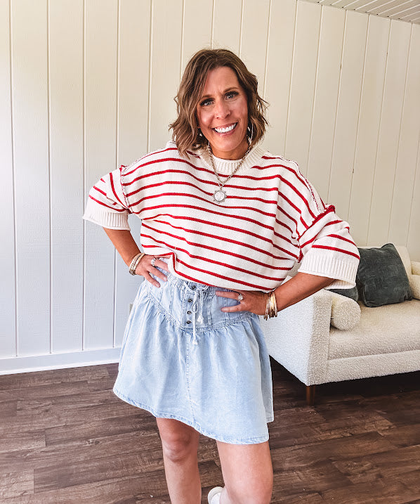 Soft cream and red striped 3/4 sleeve sweater with ribbed round neck, loose cuffs and hem.