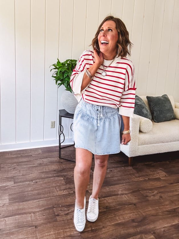 Light wash Tencel mini skirt with partial metal button down front with pleats and elastic drawstring waist.