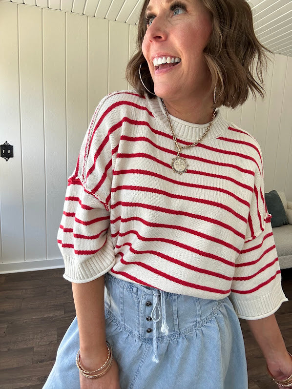 Soft cream and red striped 3/4 sleeve sweater with ribbed round neck, loose cuffs and hem.