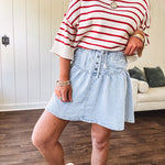 Light wash Tencel mini skirt with partial metal button down front with pleats and elastic drawstring waist.
