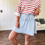 Light wash Tencel mini skirt with partial metal button down front with pleats and elastic drawstring waist.