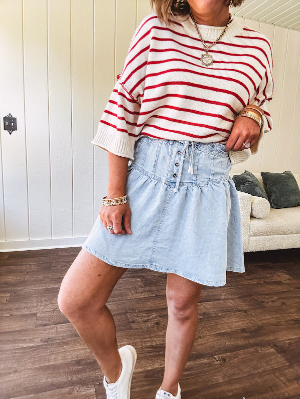 Light wash Tencel mini skirt with partial metal button down front with pleats and elastic drawstring waist.