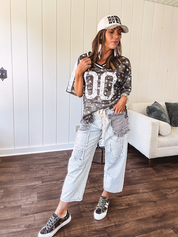 Camo print jersey featuring black and white trim at the V neck, white satin trim down the shoulders and a double 0 on the front.