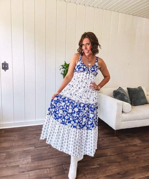 Blue and white floral maxi dress with tiered skirt, tie at the bodice, adjustable skinny straps and fully lined with smocking at the back.