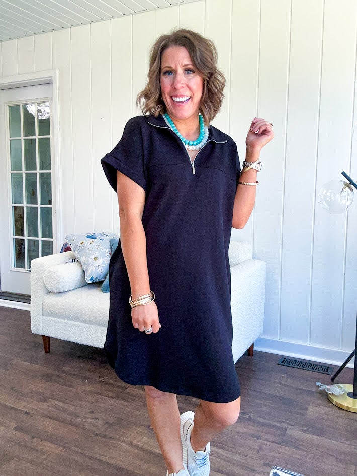 The scoop hem is a flattering fit that is sure to be the star of the show. This black 1/4 zip dress combines comfort with contemporary style, featuring a distinctive scoop hem that creates an elegant silhouette.