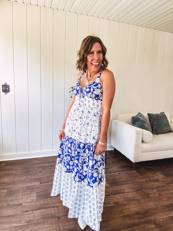 Blue and white floral maxi dress with tiered skirt, tie at the bodice, adjustable skinny straps and fully lined with smocking at the back.