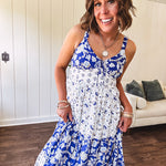 Blue and white floral maxi dress with tiered skirt, tie at the bodice, adjustable skinny straps and fully lined with smocking at the back.
