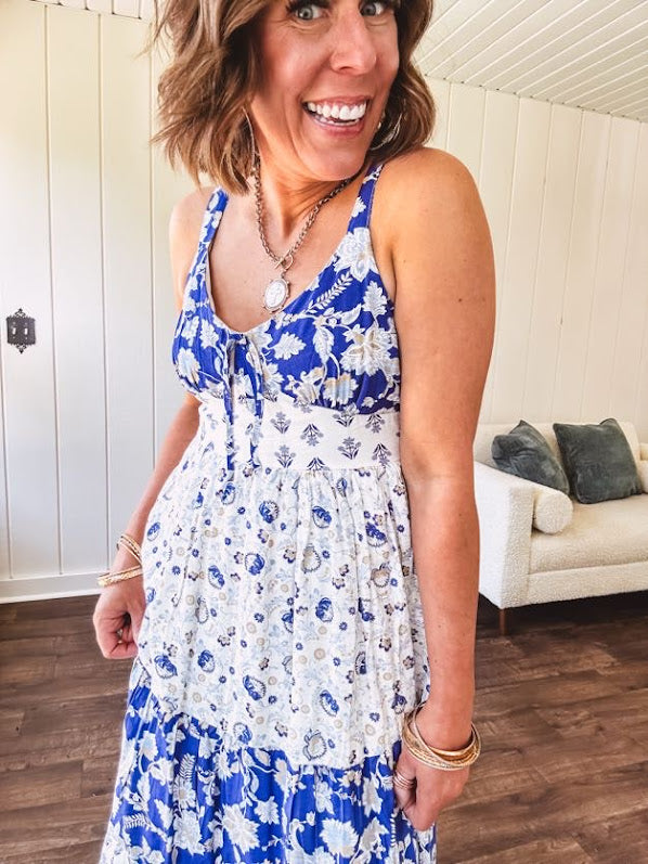 Blue and white floral maxi dress with tiered skirt, tie at the bodice, adjustable skinny straps and fully lined with smocking at the back.