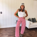 Thin, stretchy red and white checkered barrel pants with button and zipper closure.