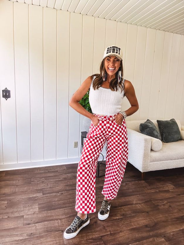 Thin, stretchy red and white checkered barrel pants with button and zipper closure.