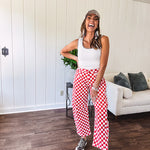Thin, stretchy red and white checkered barrel pants with button and zipper closure.