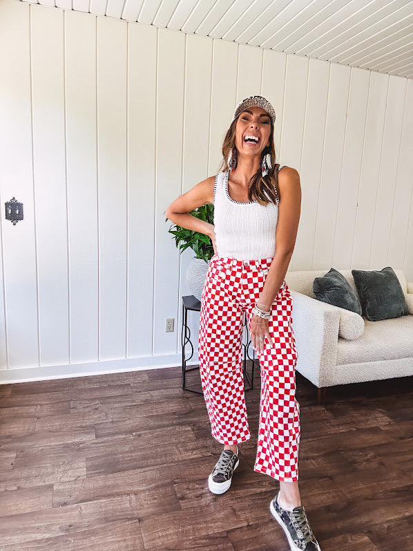 Thin, stretchy red and white checkered barrel pants with button and zipper closure.