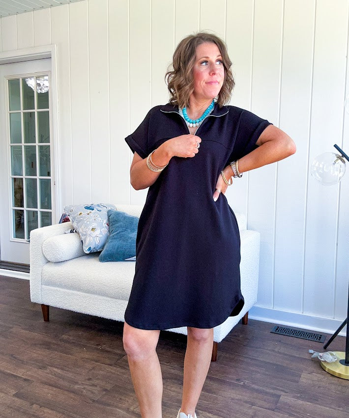 The scoop hem is a flattering fit that is sure to be the star of the show. This black 1/4 zip dress combines comfort with contemporary style, featuring a distinctive scoop hem that creates an elegant silhouette.