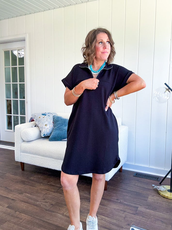 The scoop hem is a flattering fit that is sure to be the star of the show. This black 1/4 zip dress combines comfort with contemporary style, featuring a distinctive scoop hem that creates an elegant silhouette.